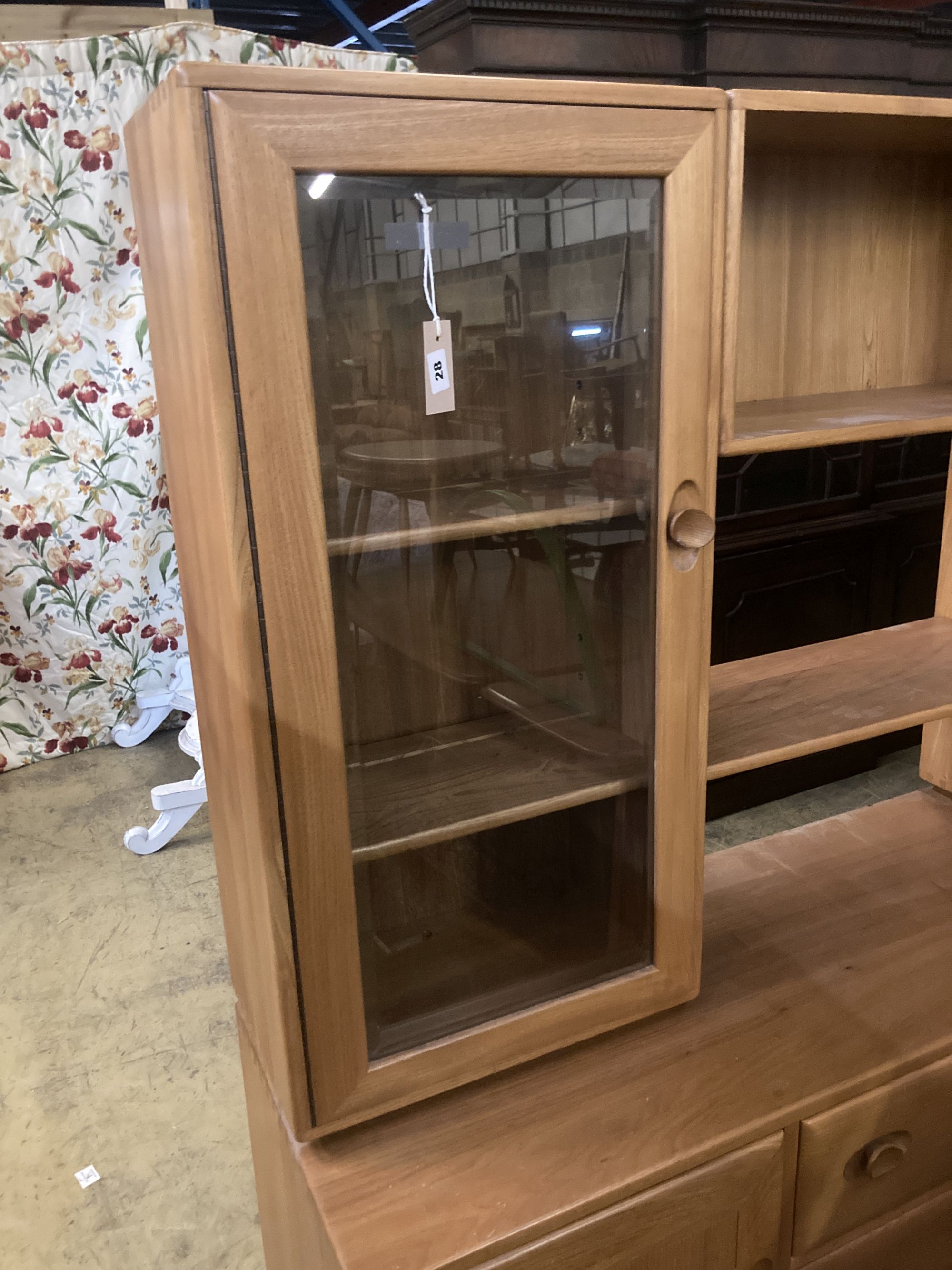 An Ercol elm glazed bookcase, width 155cm depth 44cm height 162cm